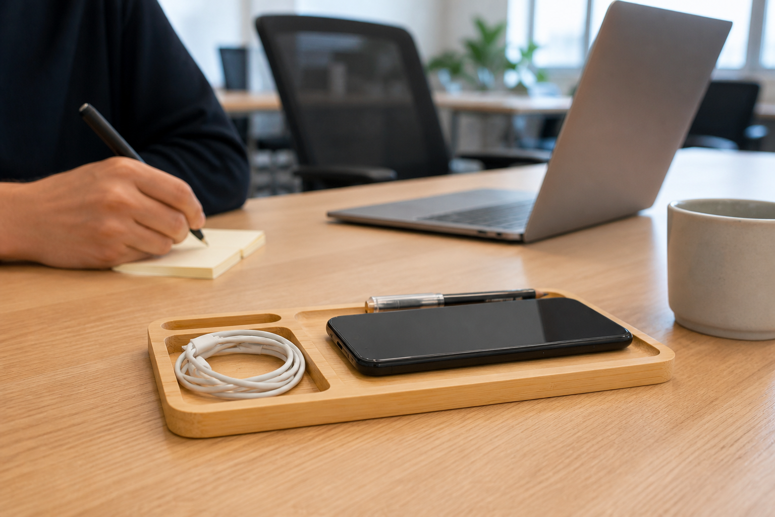 One W119 bamboo wireless charging organizer holding a phone, cable and pens on a shared coworking desk